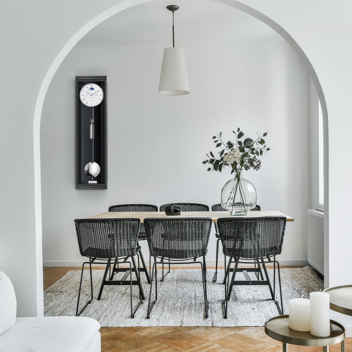 Moderne Wanduhr Classica K 100 M in elegantem Esszimmer-Ambiente mit schwarzem Gehäuse