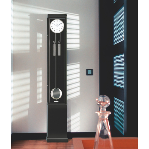 Excelsia Standuhr von Erwin Sattler elegant platziert im modernen Innenraum mit Lichtspiel