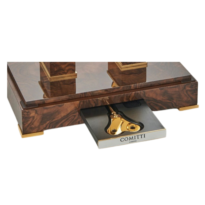 Integriertes Schubfach im Nussbaum-Sockel der Comitti The Navigator Gold mit graviertem Comitti-Schlüssel.