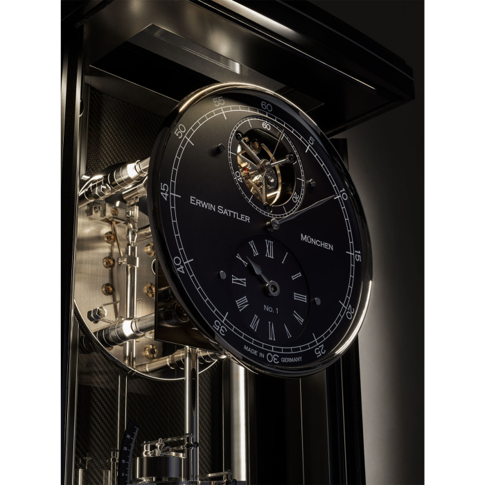 Nahaufnahme des schwarzen Zifferblatts mit Tourbillon der Erwin Sattler Illumina Secunda Carbon bei gedämpfter Beleuchtung.