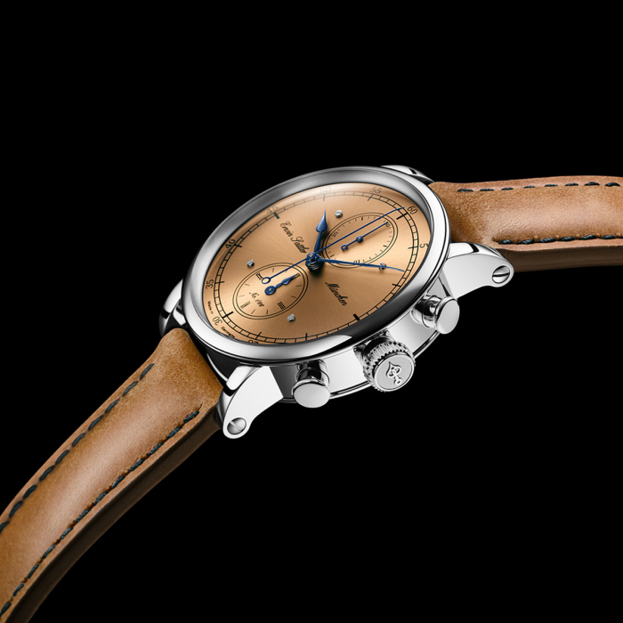 Detailansicht des Erwin Sattler Chronographen mit geschwungenem Gehäuse und polierten Drückern vor schwarzem Hintergrund