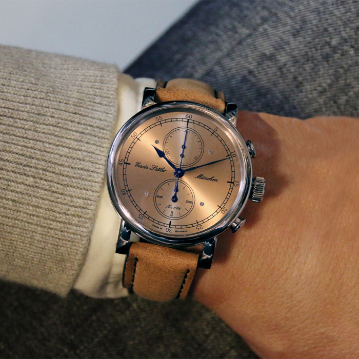 Erwin Sattler Chronograph mit braunem Lederband getragen über beigem Pullover und Anzugärmel