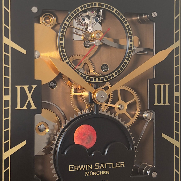 Detailansicht der Lunaris Sanguis Tischuhr mit goldfarbenen Zeigern, sichtbarem Tourbillon und rotem Mondphasendisplay